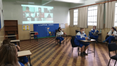 Iniciando ao ensino híbrido, com aulas acontecendo no formato presencial e virtual. As aulas estão sendo transmitidas ao vivo para os estudantes que estão em casa e todos podem participar em tempo real.