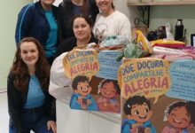 Grupo de estudantes apresenta doações de doces e mensagens para crianças do Lar Encantado durante entrega da campanha solidária.