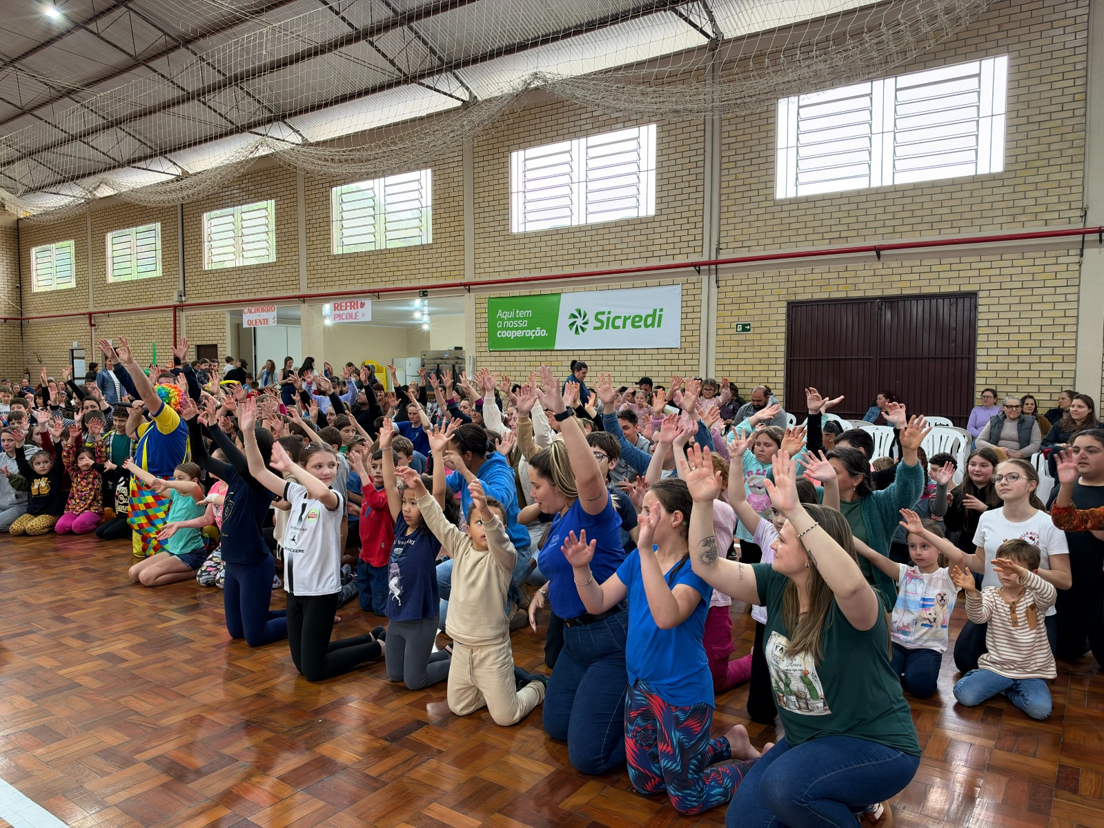 Crianças e familiares participam de atividade no Ginásio Municipal de Esportes durante celebração do Dia das Crianças em Relvado.