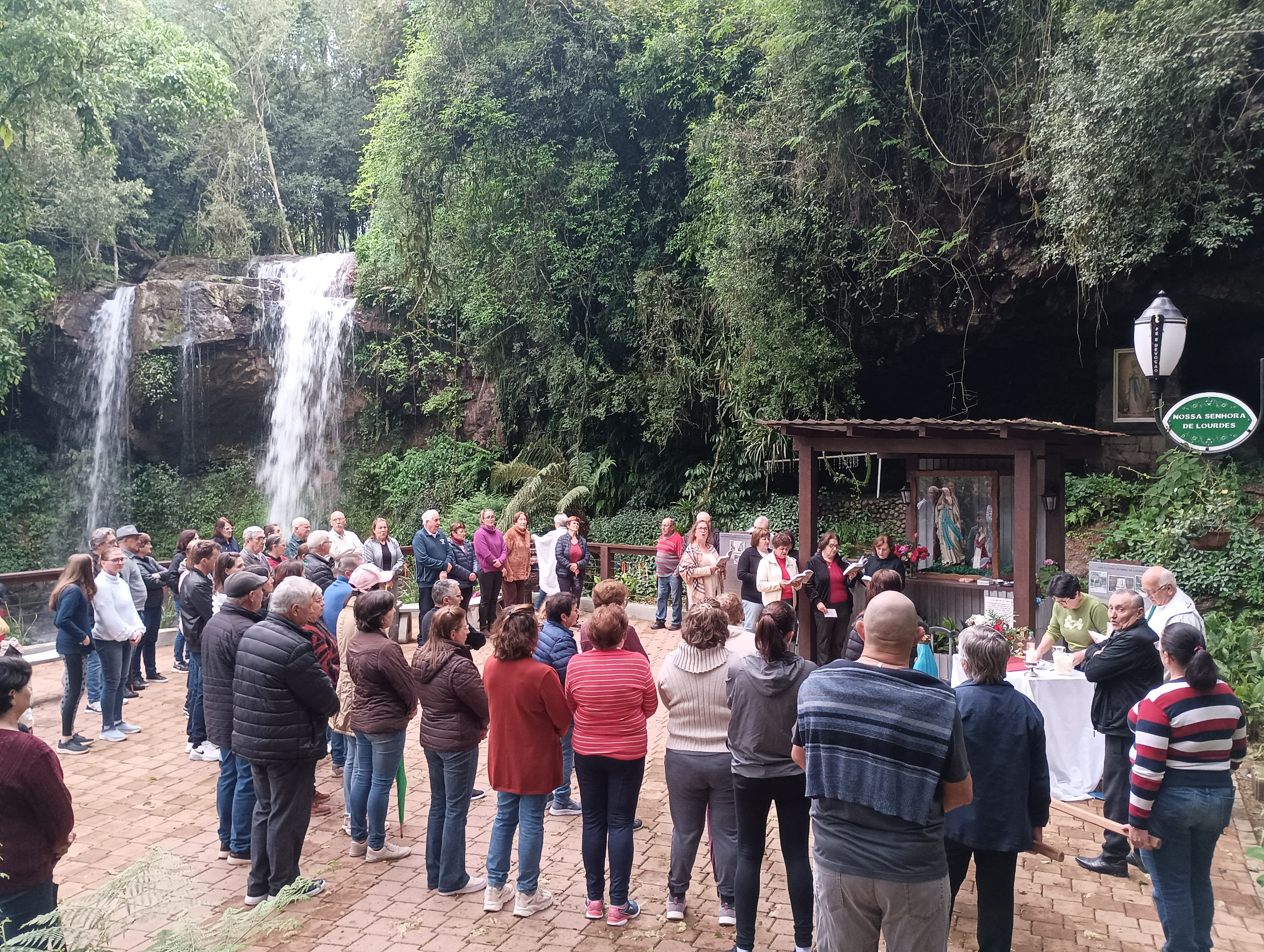 Fiéis participam de procissão na Gruta Nossa Senhora de Lourdes durante celebração de Nossa Senhora Aparecida em Relvado.