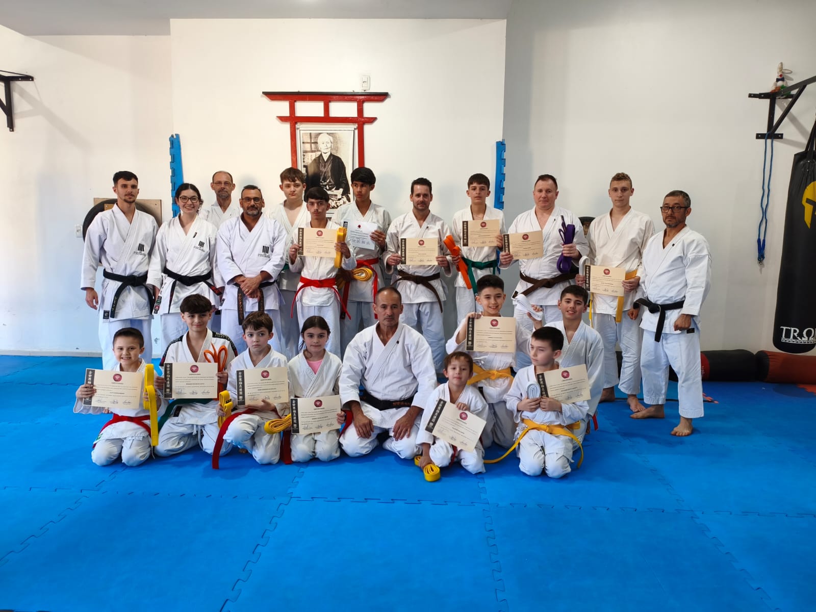 Atletas do Dojo Kaizen posam com certificados após exame de graduação de faixas em Encantado.