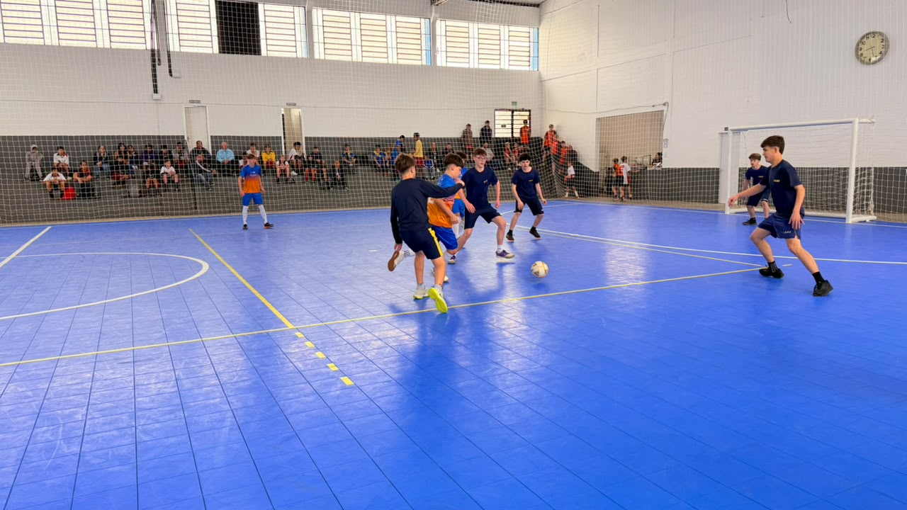 Estudantes disputam partida de futsal durante os Jogos Escolares Municipais de Roca Sales em quadra coberta.
