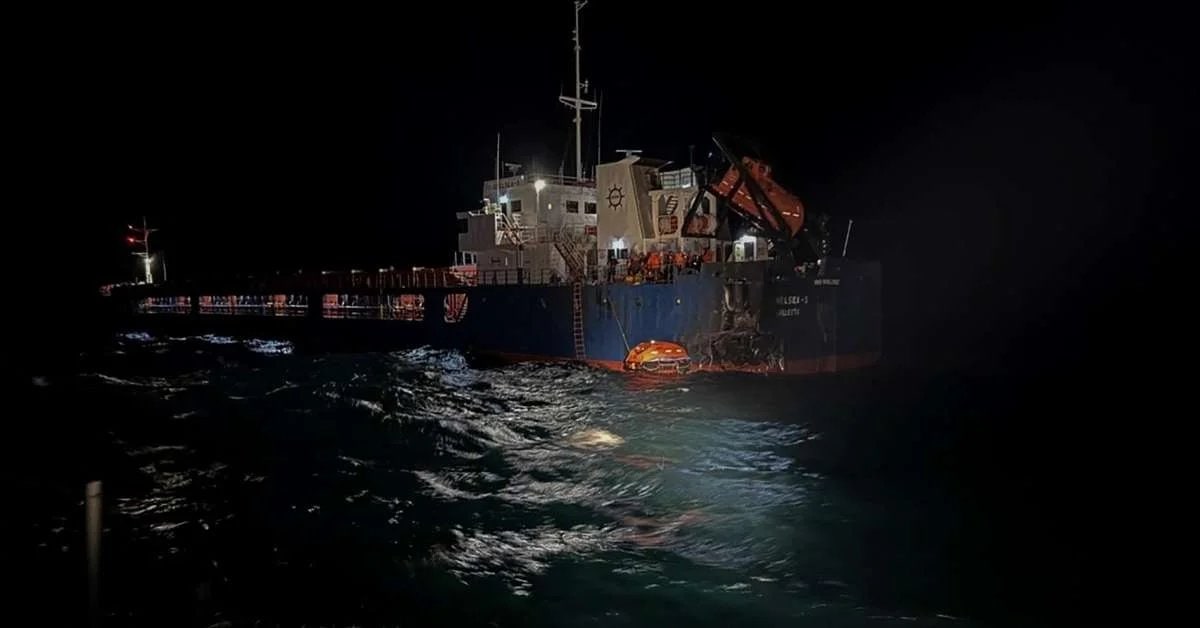 Navio mercante iluminado à noite no Mar Negro após ataque que deixou desaparecidos.
