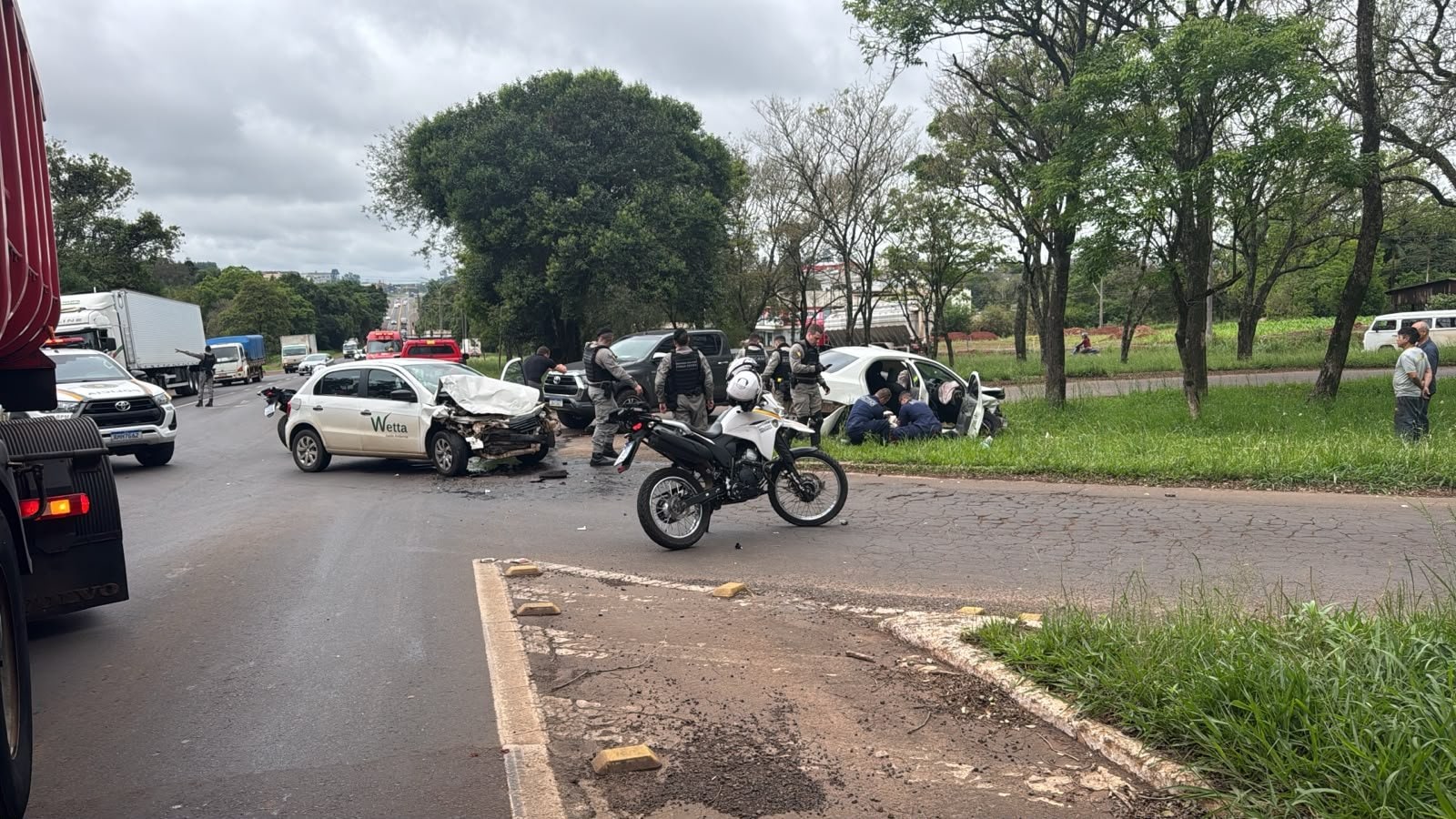 Veículo branco danificado após colisão na ERS-130 em Lajeado, com policiais e equipes de emergência no local do acidente.